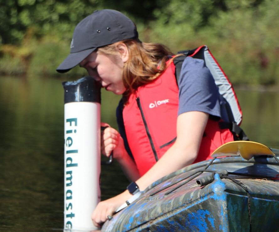 persona in kayak using aquascope to view in the water