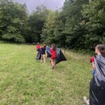 campers walking with trash bags full of Japanese knotweed