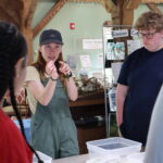 instructor holding an aquatic plant and pointing to it