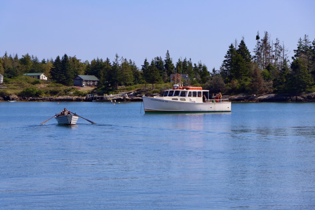 Dory rowing out to a lobster boat